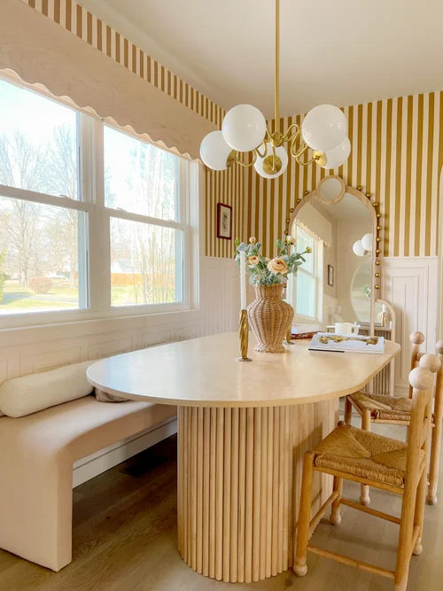 Dining room with a round wooden table, chairs, and a chandelier.