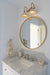 Bathroom vanity with round mirror, light fixture, and marble countertop.