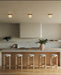 Three square alabaster flush mounts hang over a modern kitchen island