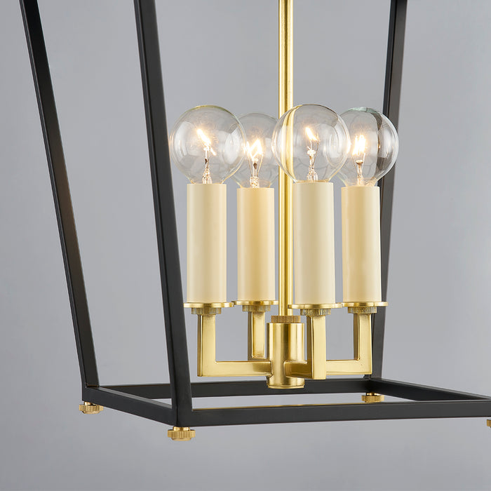 Modern lantern with gold accents and clear glass shades on a gray background
