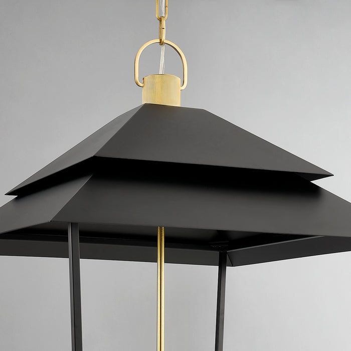 Black layered pendant light with gold accents on a gray background