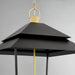 Black layered pendant light with gold accents on a gray background