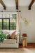 Living room with a white sofa, decorative pillows, a small table, and a wall sconce.