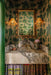 Decorative bathroom with marble sink, gold fixtures, and patterned wallpaper.