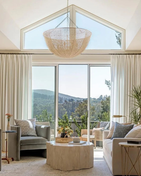 Modern living room with large windows, neutral decor, and a mountain view.