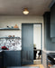 Modern kitchen with dark blue cabinets and a marble backsplash.