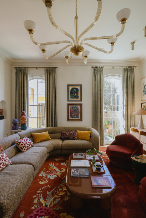 Living room with a chandelier, sectional sofa, and coffee table.