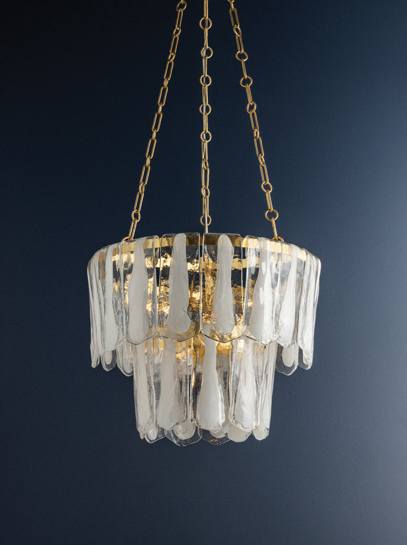 Chandelier with clear glass elements and gold chain on a dark blue background