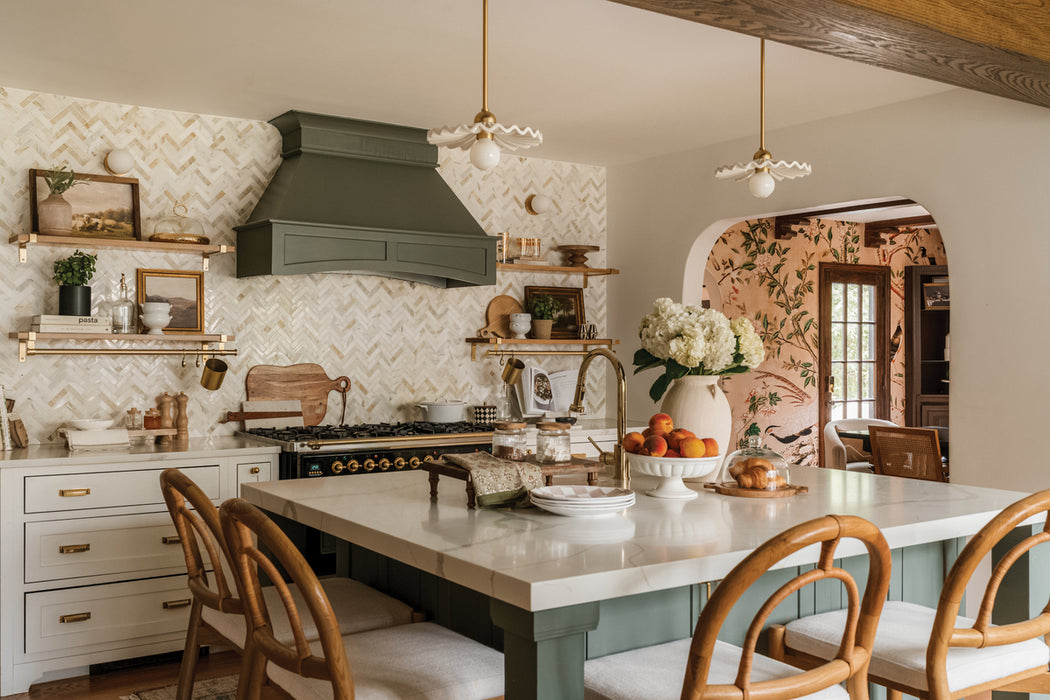 Modern kitchen with marble countertops, wooden chairs, and decorative elements.