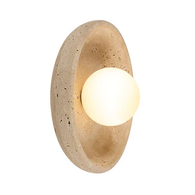 Oval travertine wall light with a glowing white globe center.