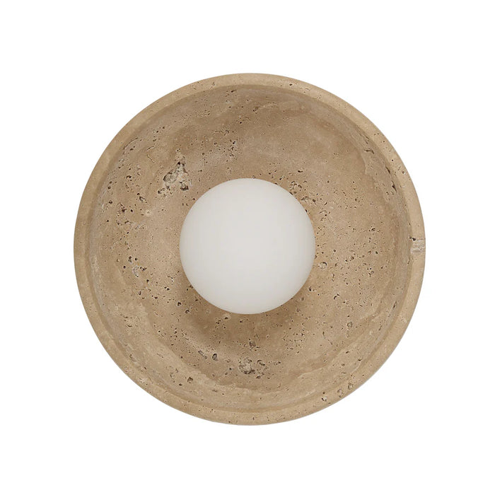 Wall light with a round white globe set in a curved beige stone frame.