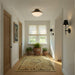 Modern home hallway with two black sconces hanging on the wall.