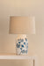 Table lamp with floral design on a beige surface against a light background