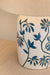 Ceramic lamp base with blue floral patterns on a beige background