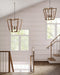 Staircase with wooden railings and pendant lights in a well-lit room with large windows.