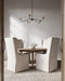Dining room with wooden table and beige chairs under a chandelier.