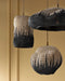 Three woven pendant lights hanging against a gold wall.