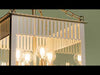 Pendant light fixture in a traditional box lantern style, featuring a structured, rectangular frame with clean lines. The design is updated with scalloped edges and slatted detailing that add texture and visual interest. Inside, four light sources provide a warm, even glow, illuminating the interior of the frame and enhancing the fixture’s classic yet refreshed appearance