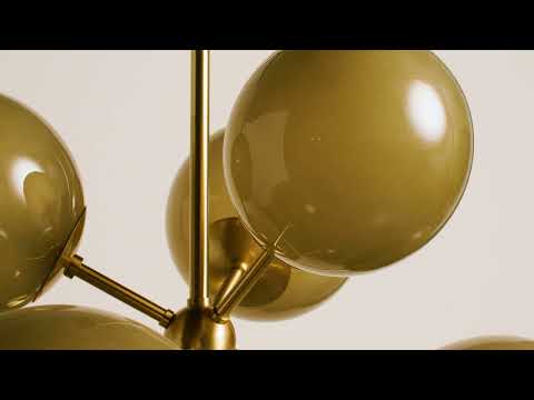 Pendant light fixture with a mid-century modern Sputnik-inspired silhouette, featuring multiple slightly irregular light bronze glass globes radiating outward from a central sphere. The center is finished in aged brass, adding warmth and contrast. Each glass globe softly diffuses light, creating a warm, ambient glow while emphasizing the fixture’s sculptural, starburst form.