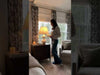 A woman swaps out her bedside table lamp for a new white lamp