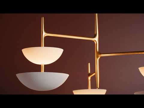 Chandelier-style light fixture featuring multiple milky glass shades with a smooth, opaque finish. The glass diffuses light evenly, creating a soft, warm glow without harsh glare. The shades are arranged around a central structure, providing balanced ambient illumination and a clean, modern appearance.